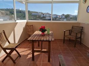 a table and chairs in a room with windows at La Roca de Setenil in Setenil