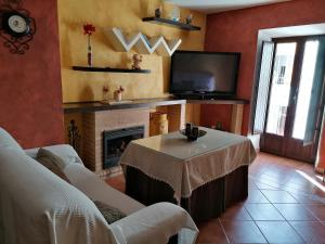 sala de estar con mesa y chimenea en La Roca de Setenil, en Setenil