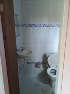 a bathroom with a toilet and a sink at Residencial Portuguesa in Natal