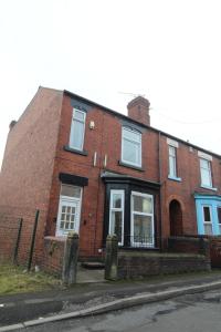 a red brick house with white windows on a street at Rockcliffe House in Rawmarsh
