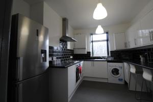 een keuken met een koelkast en een wasmachine bij Rockcliffe House in Rawmarsh