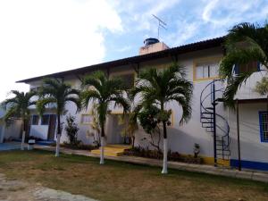 a white house with palm trees in front of it at Residencial Portuguesa in Natal +20 photos