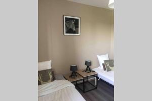 Zimmer mit 2 Betten und einem Bild an der Wand in der Unterkunft La maison d'Adélie in Bourbourg