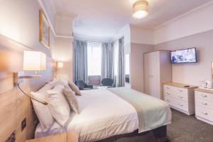 a hotel room with a bed and a tv at Lindum Lodge in Torquay