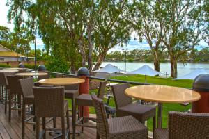 
a patio area with tables, chairs, and benches at Pretoria Hotel in Mannum
