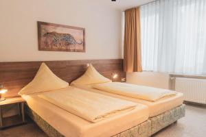 a hotel room with two beds in a bedroom at Parkhotel Friedrichstrasse in Gießen +17 photos