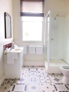 uma casa de banho com um lavatório, um chuveiro e um WC. em Seaview House em Queenscliff