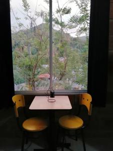 a table and two chairs in front of a window at Casa chill out in Minca