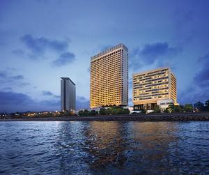 two tall buildings next to a body of water at The Oberoi Mumbai in Mumbai