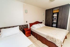 sypialnia z 2 łóżkami i szafą w obiekcie Alpro Urbano Oriente w mieście Iquique