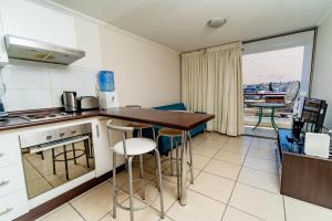 a kitchen with a table and chairs in a room at Alpro Urbano Oriente in Iquique