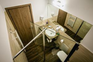 Un baño con lavabo, espejo e inodoro. en Colors Residence, en Cluj-Napoca 30 fotos más