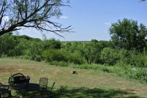 Vernon的住宿－Rustic Red River Retreat，树木繁茂的田野里的桌椅