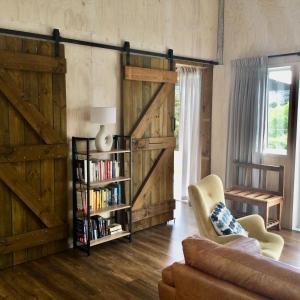 a living room with a sliding barn door at Warkworth Barn Retreat in Warkworth