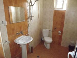 a bathroom with a sink and a toilet and a mirror at Guest House Stenli in Primorsko +69 photos