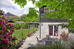 a patio with a table and chairs in front of a house at Number 10 Arrowtown Sleeps 12 in Arrowtown