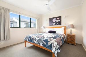 um quarto com uma cama e uma janela em Mount Sunset - Mt Maunganui Townhouse em Mount Maunganui