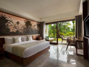 sypialnia z dużym łóżkiem i dużym oknem w obiekcie Adiwana Suweta w mieście Ubud