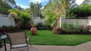 a yard with a white fence and a vase on the grass at Se-Ayr BnB at Lighthouse in Port Macquarie