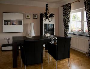 Ferienhaus Ginsterblüte في شليدن: غرفة طعام مع طاولة سوداء وكراسي