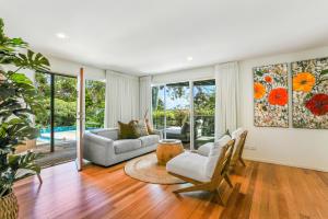 a living room with a couch and a table at Naturally majestic, Noosa Heads in Noosa Heads