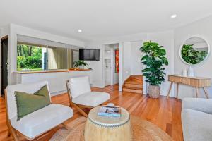 a living room with two chairs and a table at Naturally majestic, Noosa Heads in Noosa Heads