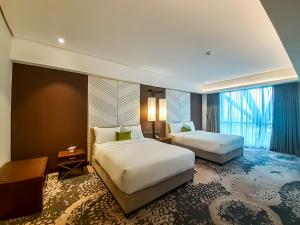 马尼拉The Excelsior Hotel Las Piñas的有两张床和一扇窗户的酒店房间