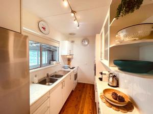 a kitchen with white cabinets and a sink at Bombora in Callala Beach