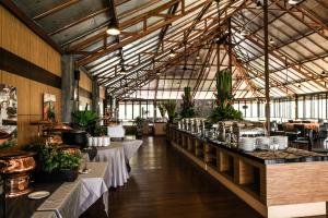 JSI Resort في بونشاك: مطعم بطاولات ونباتات في مبنى