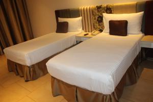 a hotel room with two beds and a telephone at Pride Elite, Phaltan in Phaltan