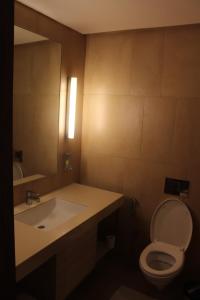 a bathroom with a sink and a toilet and a mirror at Pride Elite, Phaltan in Phaltan