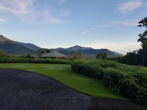 a golf course with green grass and mountains in the background at Daintree Holiday Homes - La Vista in Cow Bay