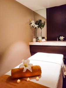 um quarto com uma cama com uma flor em The Excelsior Hotel Las Piñas em Manila