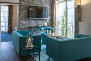 un soggiorno con divani blu e TV di Villa Katharina Ferienwohnungen a Willingen