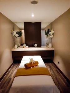 um quarto com uma cama com um cobertor amarelo e flores em The Excelsior Hotel Las Piñas em Manila