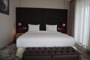 a bedroom with a large bed and a leather couch at The Curve by the Park Apartments in Nairobi