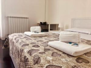 パレルモにあるLiolà Home Palermoのベッドルーム1室(ベッド2台、ベッド1台にタオル付)