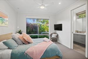 - une chambre avec un grand lit et une fenêtre dans l'établissement Ocean Cove Chalet, à Quindalup