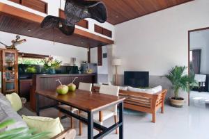 a living room with a table and a couch at 2BR Villa Violetta - Minggu Villas in Kerobokan