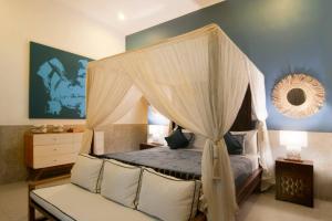 a bedroom with a canopy bed and a couch at 2BR Villa Violetta - Minggu Villas in Kerobokan +25 photos