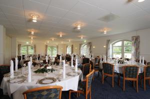 una sala de banquetes con mesas y sillas con manteles blancos en Hotel Søparken, en Åbybro