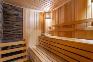 uma sauna com painéis de madeira e uma parede de tijolos em Hotel Grace Nairi em Sochi