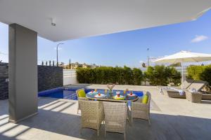 a patio with a table and chairs and a pool at Pernera Beach Villa in Protaras