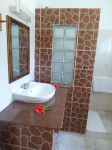 a bathroom with a sink and a mirror at Zerof Self Catering Apartments in La Digue