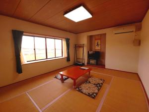 een woonkamer met een tafel en een raam bij Nanauraso in Sado