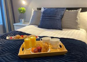 a tray of food on a bed with drinks and snacks at The North Wales Gathering - 9 Bedroom - EV Charging in Flint