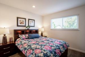 a bedroom with a bed with a floral bedspread and a window at Luxury stay near Oakridge Mall for vacation/work in San Jose