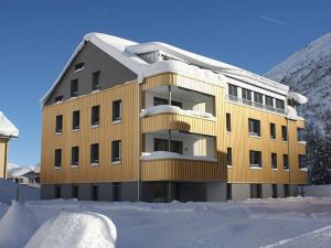 a yellow building with snow in front of it at Realp-Andermatt 3,5 locali giardino privato In mezzo la natura, spettacolare per appassionati montanbike, pesca ecc In inverno fai sci di fondo dal giardino e con il treno davanti a casa si raggiunge in 5min il comprensorio scistico di Andermatt in Realp