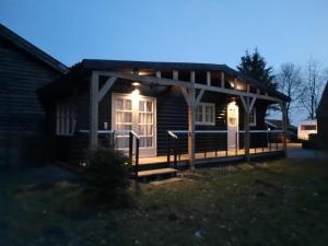 Cabaña con luces en el porche por la noche en Chalet Het Wollinghuisje, en Vlagtwedde