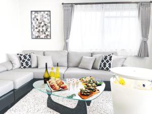 uma sala de estar com um sofá e uma mesa com comida em OUCHI HOTEL SUITE Temma em Hiroshima